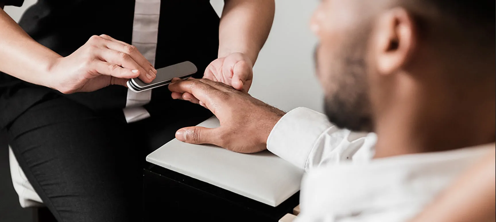 A manicure being given to a man at the nail station